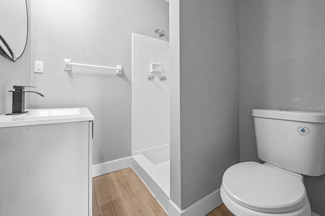 4445 Stuart Ave, Titusville, FL 32780 - full bath featuring tiled shower, toilet, wood finished floors, vanity, and baseboards