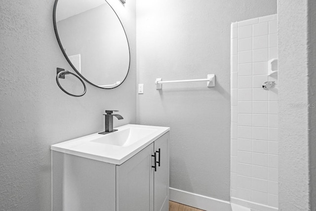 4445 Stuart Ave, Titusville, FL 32780 - bathroom featuring vanity, wood finished floors, a textured wall, and baseboards