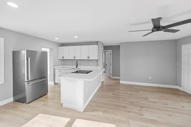 4445 Stuart Ave, Titusville, FL 32780 - kitchen featuring freestanding refrigerator, light countertops, a peninsula, a ceiling fan, and white cabinets
