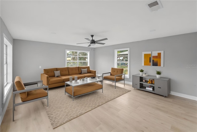 4445 Stuart Ave, Titusville, FL 32780 - living room featuring light wood-style flooring, a ceiling fan, and baseboards
