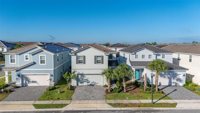 traditional-style home with a residential view, a tile roof, and decorative driveway