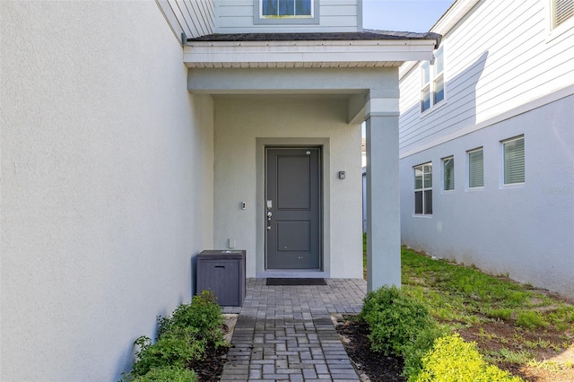 view of exterior entry with stucco siding