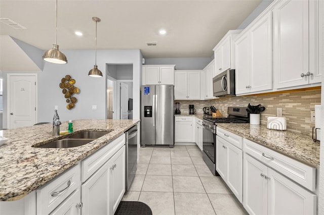 kitchen featuring appliances with stainless steel finishes, a sink, tasteful backsplash, white cabinets, and recessed lighting