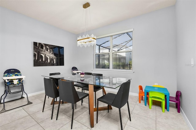 dining space with a chandelier, baseboards, and light tile patterned floors