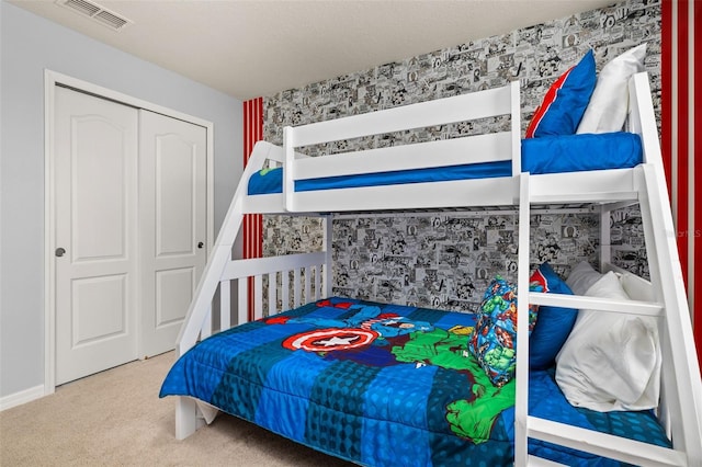 bedroom with carpet flooring, a closet, and wallpapered walls