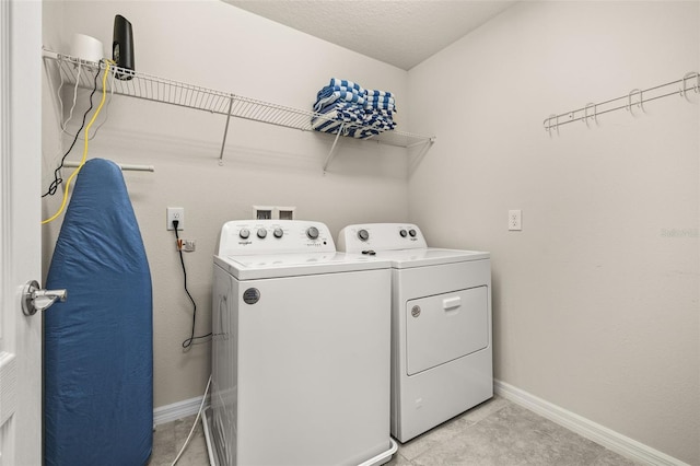 laundry room with independent washer and dryer, baseboards, and light tile patterned floors