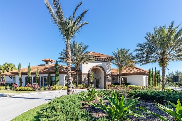 mediterranean / spanish house with stucco siding and a tile roof
