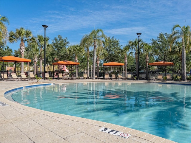 community pool with a gazebo and fence