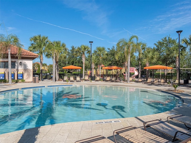 community pool with fence and a patio