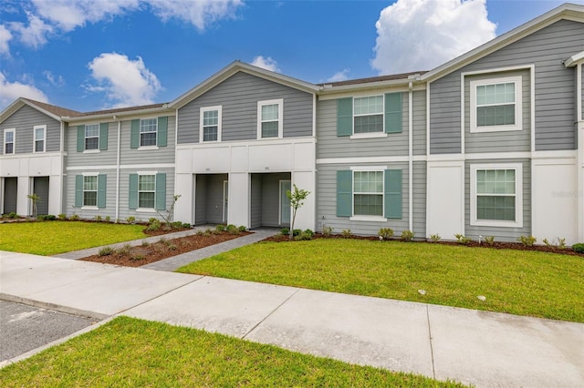 townhome / multi-family property featuring a front lawn