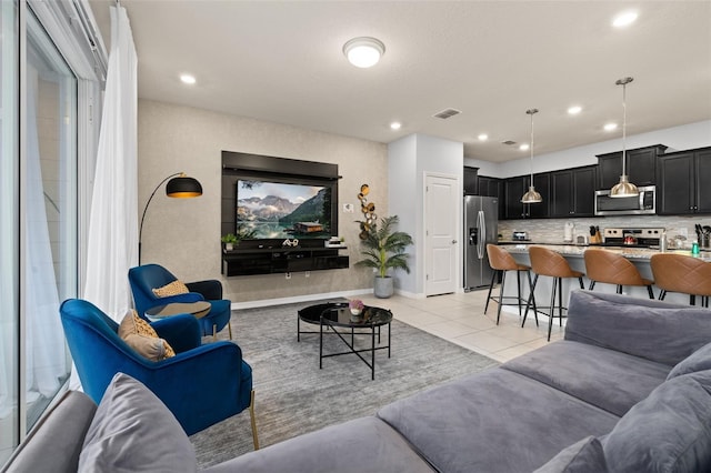 living room featuring light tile patterned floors, recessed lighting, and baseboards