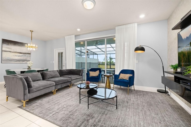 tiled living area with recessed lighting, baseboards, and a chandelier