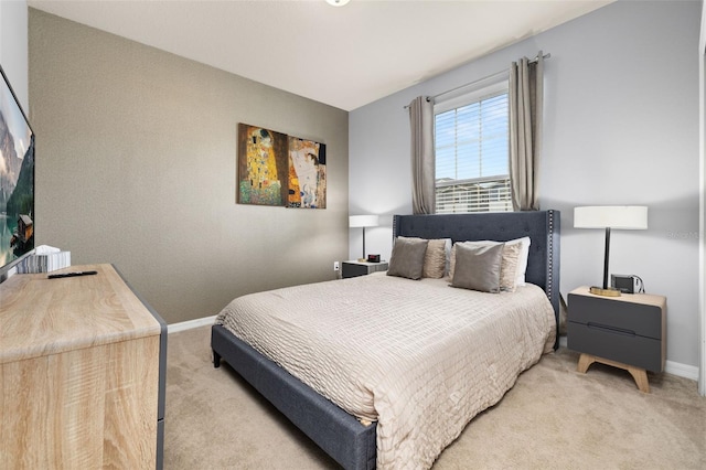 bedroom featuring light carpet and baseboards