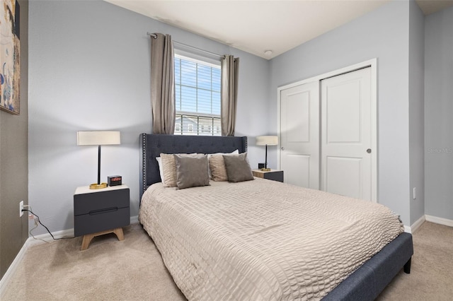 bedroom featuring light colored carpet, a closet, and baseboards