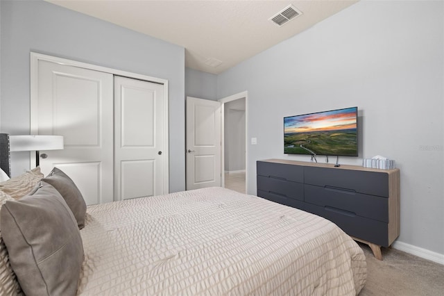 bedroom with baseboards, a closet, and light carpet