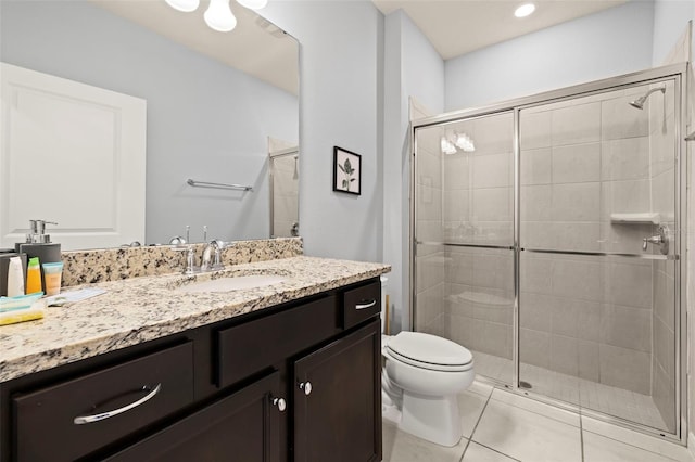bathroom featuring a shower stall, toilet, vanity, and tile patterned flooring