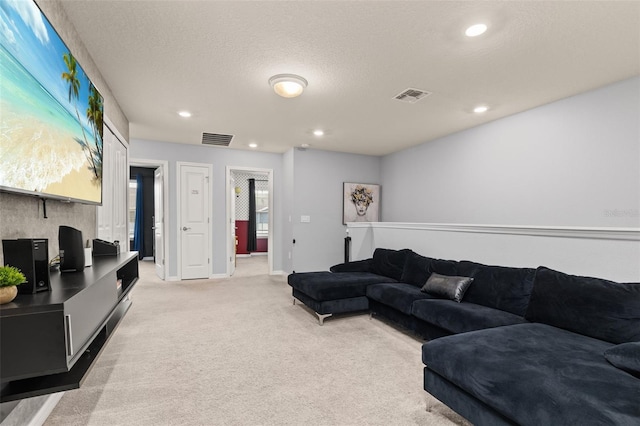 living room with light carpet, recessed lighting, baseboards, and a textured ceiling