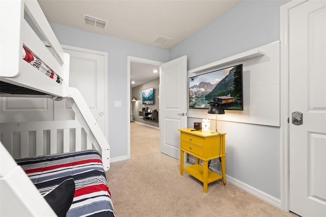bedroom with light colored carpet and baseboards