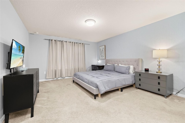 bedroom with light colored carpet, a textured ceiling, and baseboards