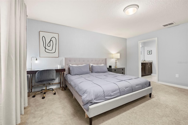 bedroom with light colored carpet, a textured ceiling, connected bathroom, and baseboards