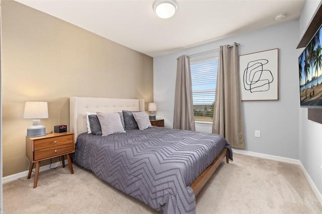 bedroom featuring light colored carpet and baseboards