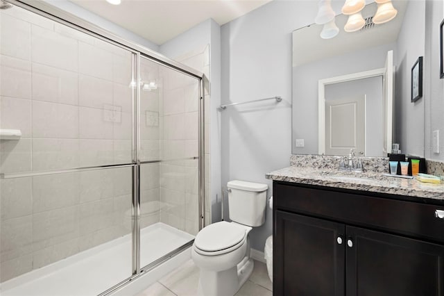 bathroom featuring toilet, a stall shower, tile patterned floors, and vanity