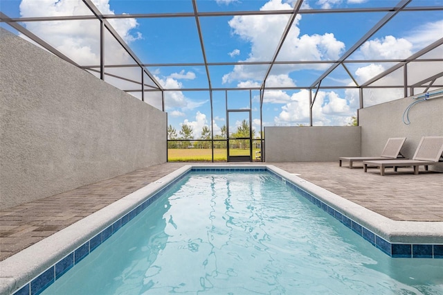 swimming pool featuring a patio and glass enclosure