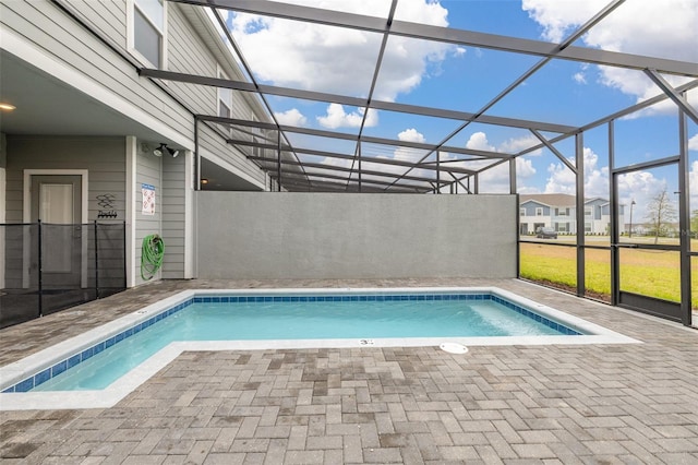 swimming pool with a patio and glass enclosure