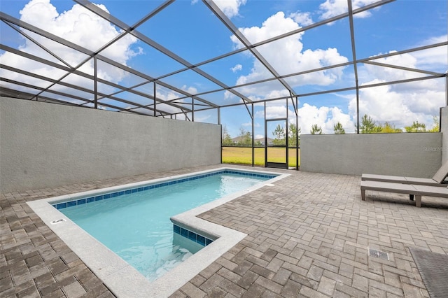 swimming pool with a patio area and glass enclosure