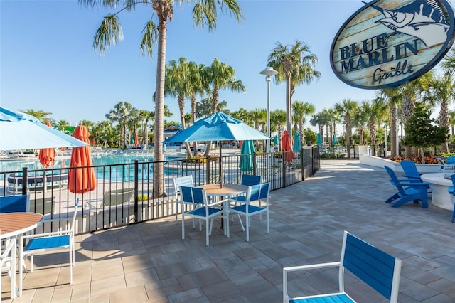 view of property's community with fence and a patio