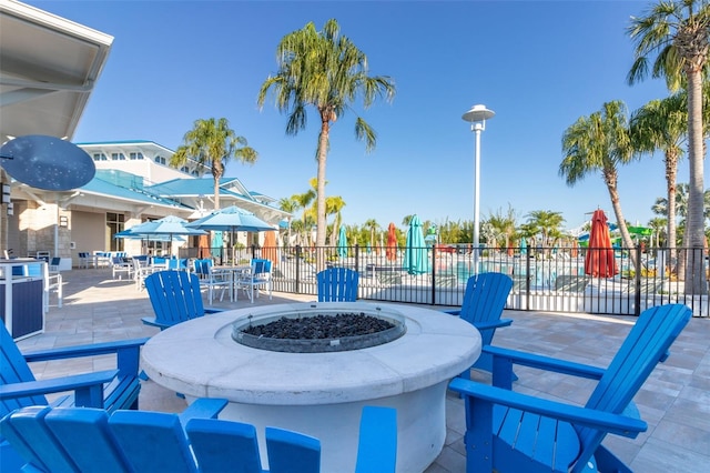 view of patio featuring a fire pit, fence, outdoor dining space, and area for grilling