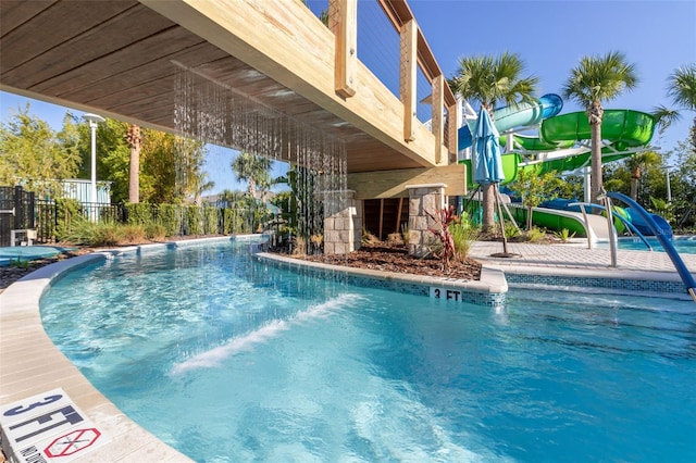 community pool with fence and a water slide