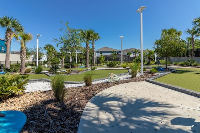 view of community with a putting area and fence