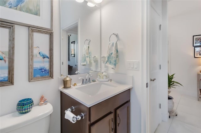 bathroom with toilet, vanity, and tile patterned flooring