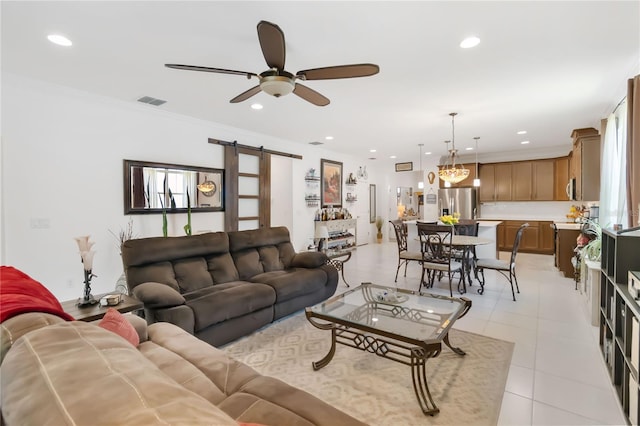 living room featuring a barn door, ceiling fan, recessed lighting, light tile patterned floors, and a chandelier