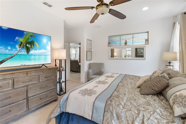 bedroom with light carpet and a ceiling fan