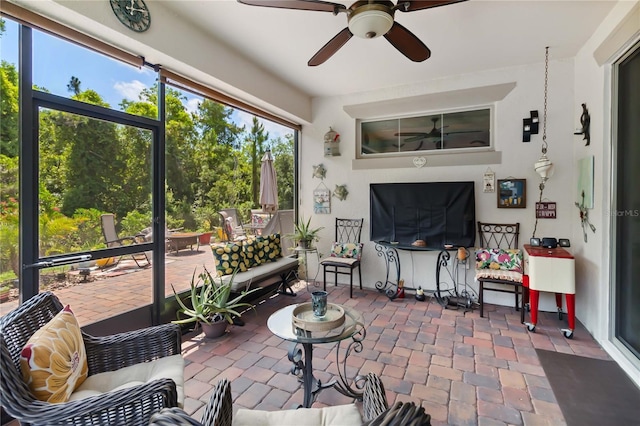 sunroom featuring a ceiling fan and outdoor lounge area