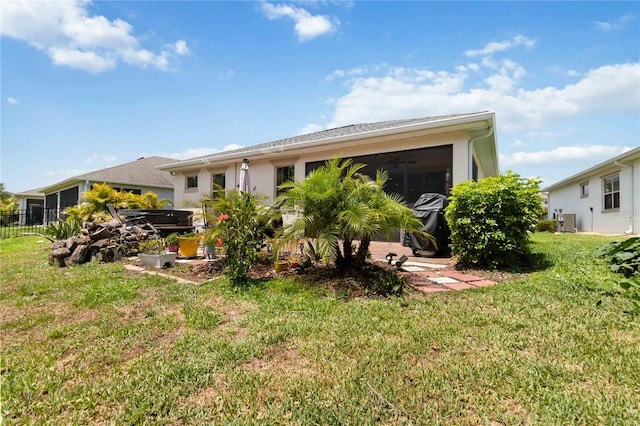back of property with a yard, cooling unit, and stucco siding