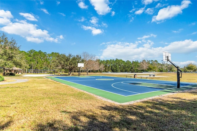 view of sport court with volleyball court, community basketball court, a yard, and view of wooded area