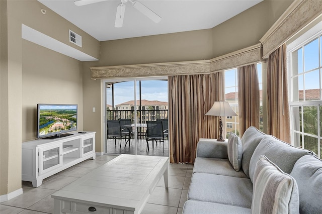 living room featuring light tile patterned flooring, a ceiling fan, a healthy amount of sunlight, and visible vents