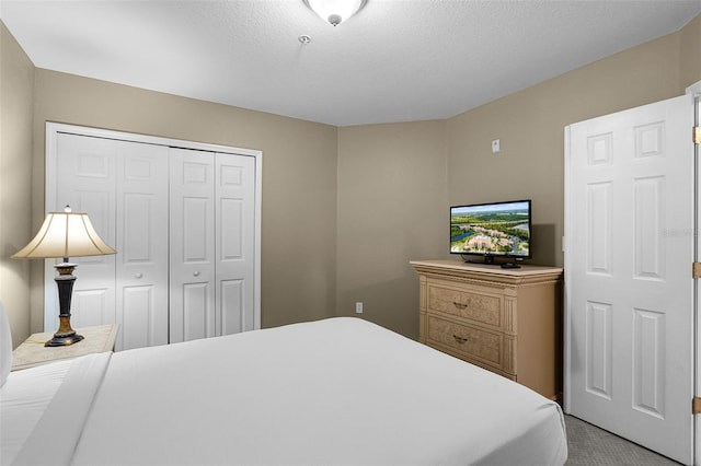bedroom featuring a closet, a textured ceiling, and carpet