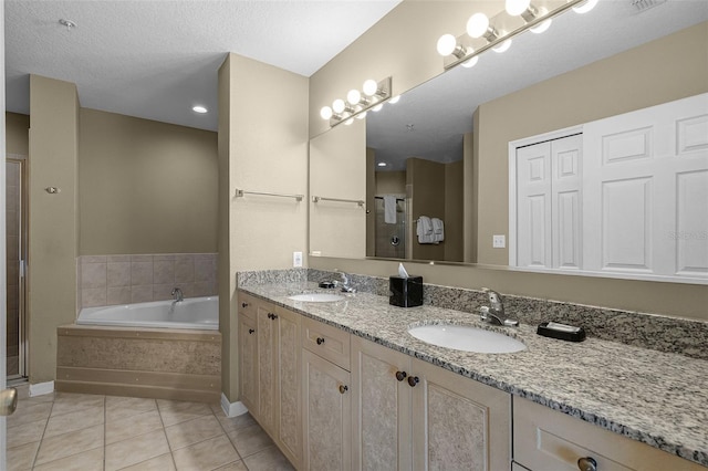 bathroom featuring a bath, tile patterned floors, a stall shower, and double vanity