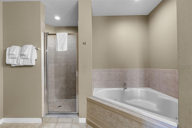 full bathroom with a jetted tub, baseboards, a shower stall, and tile patterned floors