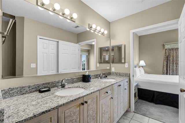 ensuite bathroom with double vanity and tile patterned floors