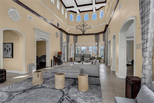 lobby featuring a towering ceiling, coffered ceiling, and beam ceiling
