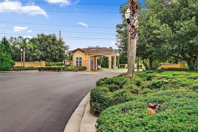 mediterranean / spanish-style house with stucco siding, asphalt driveway, and a tile roof