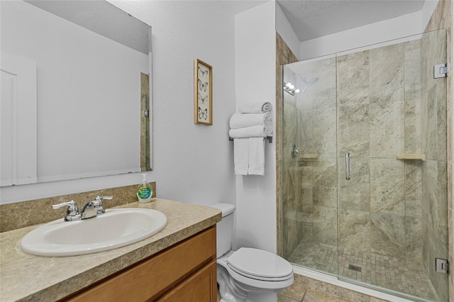 bathroom featuring toilet, a stall shower, and vanity
