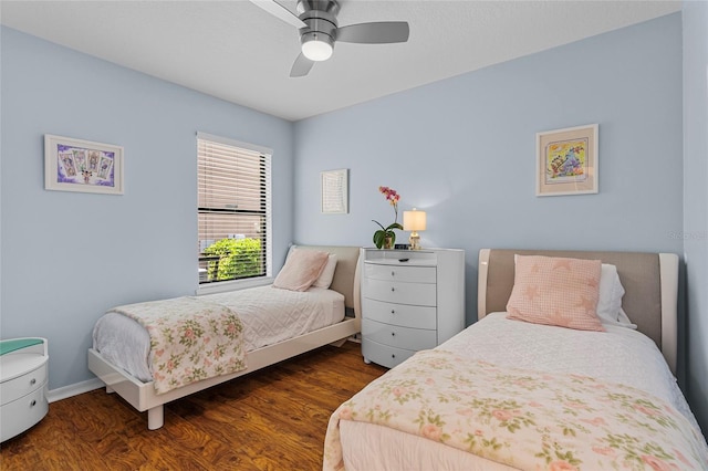 bedroom featuring wood finished floors, a ceiling fan, and baseboards