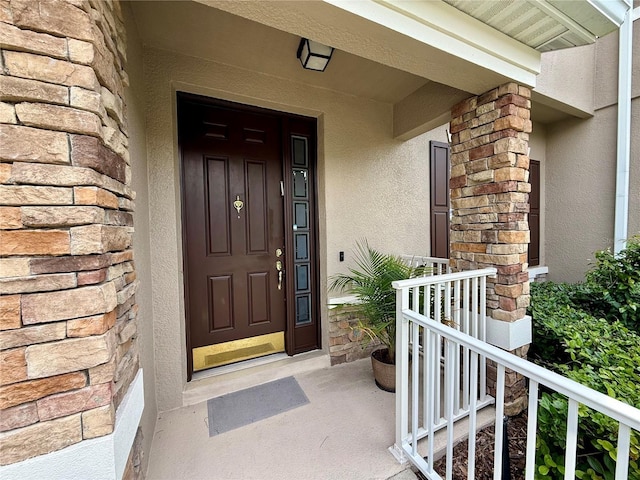 2287 Park Maitland Ct, Maitland, FL 32751 - doorway to property featuring covered porch, stucco siding, and stone siding