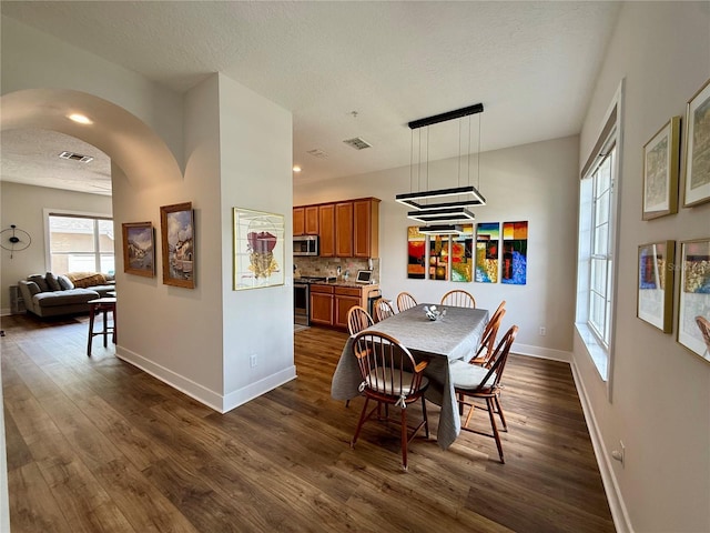 2287 Park Maitland Ct, Maitland, FL 32751 - dining space with a textured ceiling, baseboards, visible vents, arched walkways, and dark wood-style floors
